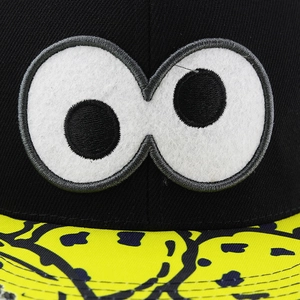 Detailed view of high-quality embroidery with cartoon eyes on black fabric cap
