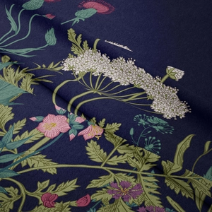 Macro detail of navy blue bohemian tapestry fabric showing floral print and soft texture