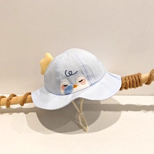 Détail du chapeau de soleil bleu clair pour bébé avec broderie de pingouin et étoile