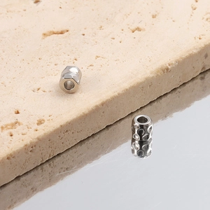 Detailaufnahme von silbernen gehämmerte und facettierte Edelstahperlen für DIY-Schmuck