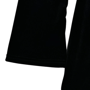 Détail du tissu en maille noire montrant les poignets et la texture douce de la robe