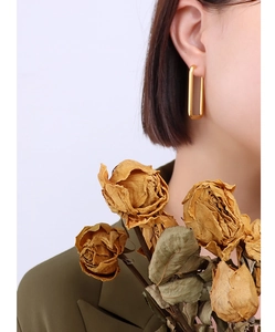 Close-up of elegant 18k gold-plated rectangular geometric earrings worn by a model