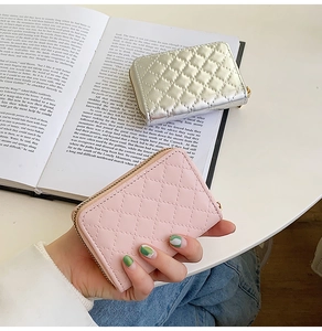 Detail of quilted card holders in silver and light pink with gold zipper closure