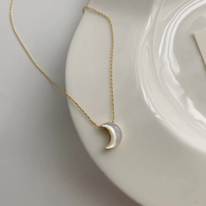 Detail of crescent moon pendant with natural mother of pearl on a fine gold chain