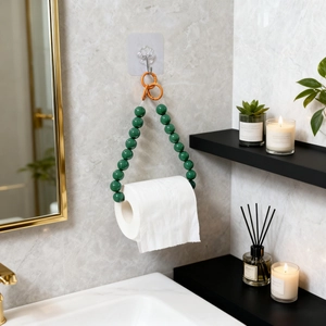 Creative dark green beaded toilet paper holder with orange ring on marble wall