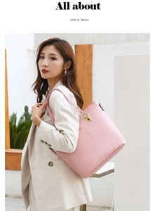 Detailed side view of pink faux leather tote bag with elegant gold hardware on model