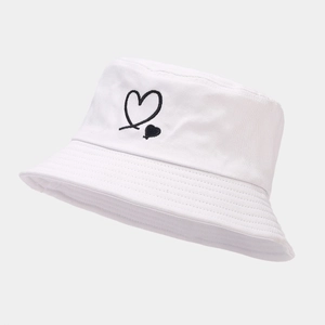 White cotton bucket hat with black heart embroidery seen from a 45-degree angle