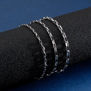 Polished silver stainless steel box chain bracelet displayed on a black stand