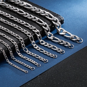 Macro detail of various widths of silver Figaro chain links on black leather