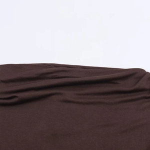Detailed macro view of soft dark brown knit fabric texture and snap dress hemline
