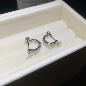 Macro shot of silver U-shaped earrings with sparkling zircon stones in a velvet box