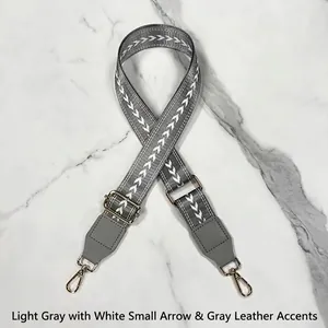 Adjustable wide grey woven shoulder strap with white arrow patterns and gold hooks