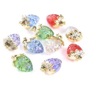 Macro view of colorful strawberry pendants with gold leaves for DIY jewelry making