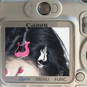 Detail of cute Y2K guitar hair clips in pink and black on retro camera screen display