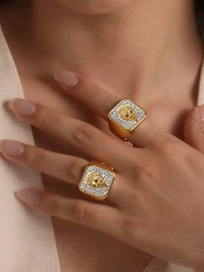 Close-up of 18K gold plated lion head rings with pavé diamonds and emerald eyes