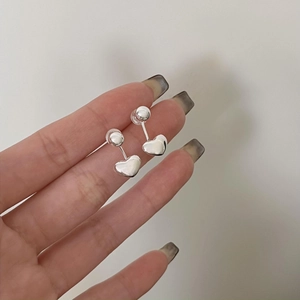 Detail of silver heart drop earrings made of 925 sterling silver with polished finish