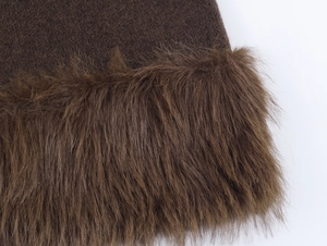 Close-up of deep brown knit fabric with premium faux fur trim and textured stitching