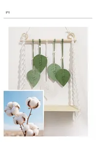 Close-up of macrame wall hanging featuring green leaf patterns and cotton rope textures