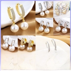 Detailed macro view of long pearl drop earrings with 18K gold micro-pave diamond settings