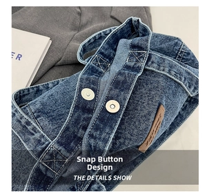 Detail view of the secure magnetic clasp closure on the blue washed denim shoulder bag
