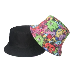 Detail of reversible bucket hat showing black canvas side and colorful cartoon monster print