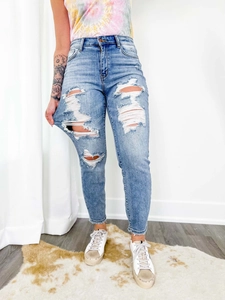 Détails du jean skinny bleu clair avec déchirures prononcées et texture effet moustaches