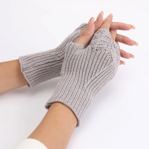 Detail shot of grey knitted fingerless gloves showing intricate fish scale pattern textures