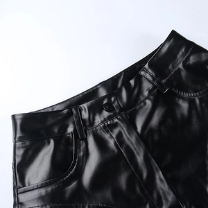 Dettaglio degli shorts neri in ecopelle a vita alta con passanti e chiusura a bottone opaco