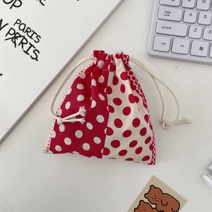 Close-up of red and white polka dot drawstring pouch with cream cotton cord fastener