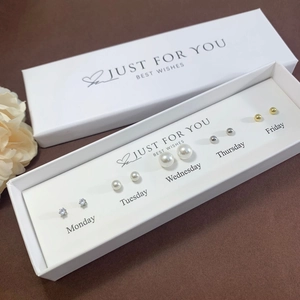 Detail of a weekly stud earring gift set featuring five pairs of pearls and rhinestones