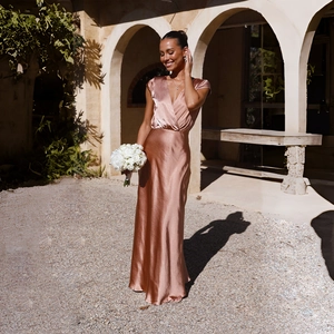 Detailed close-up of rose gold satin long dress with deep V-neck and elegant texture