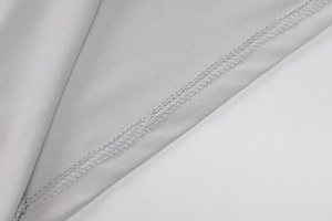Détail de couture de haute qualité sur le tissu en maille gris clair de la robe