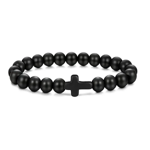Detail shot of matte black stone bead bracelet featuring a minimalist cross pendant