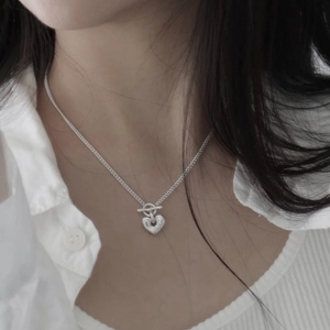 Close-up of S925 sterling silver heart toggle necklace worn with a white shirt