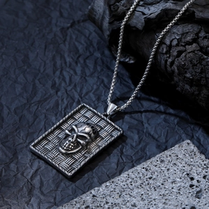 Détail macro du collier pendentif tête de mort argenté avec texture tissée sur bois