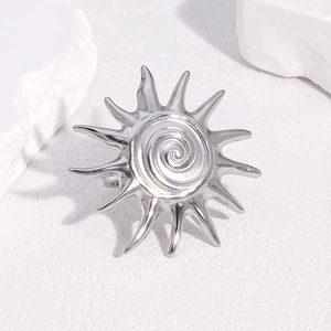 Bague soleil ouverte en acier inoxydable argenté sur un fond en pierre minimaliste