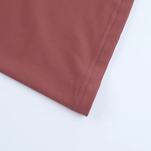 Vue détaillée montrant la double couture sur un tissu marron-rouge de haute qualité