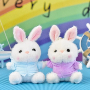 Close-up of two cute plush bunny toys wearing soft blue and purple hoodies for gifts