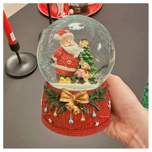 Detailed view of Christmas snow globe featuring Santa and dog with red knit base