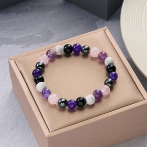 Macro detail of 8mm natural stone beads including amethyst and obsidian on a jewelry box