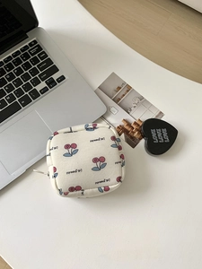 Flat lay of cream canvas cherry pouch with zipper next to office accessories