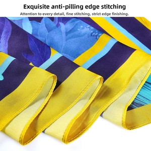 Detailed view of neatly stitched edges and floral pattern on silk scarf fabric