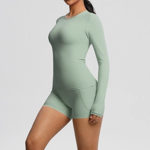Détail de l'ensemble de yoga vert sauge montrant les poignets et le tissu extensible