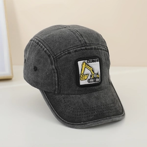 Detail view of the yellow excavator embroidery patch on the grey denim kids baseball cap