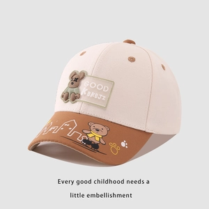 Detail of color-block baby baseball cap featuring a 3D bear patch and cartoon brim motifs