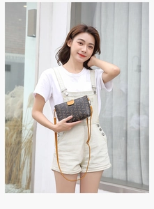 Brown rectangular crossbody bag with letter print and yellow strap on a model