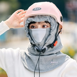 Detail view of grey windproof face mask with breathable holes and pink cycling helmet