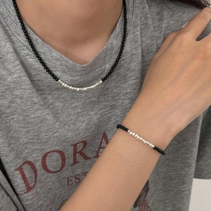 Minimalist 925 silver and black onyx bead necklace and bracelet set worn by a model