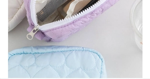 Close-up of quilted heart pattern storage bags with zipper detail and inner mesh compartment