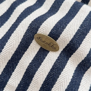 Gros plan sur la toile rayée bleu et blanc avec une plaque de logo en bronze